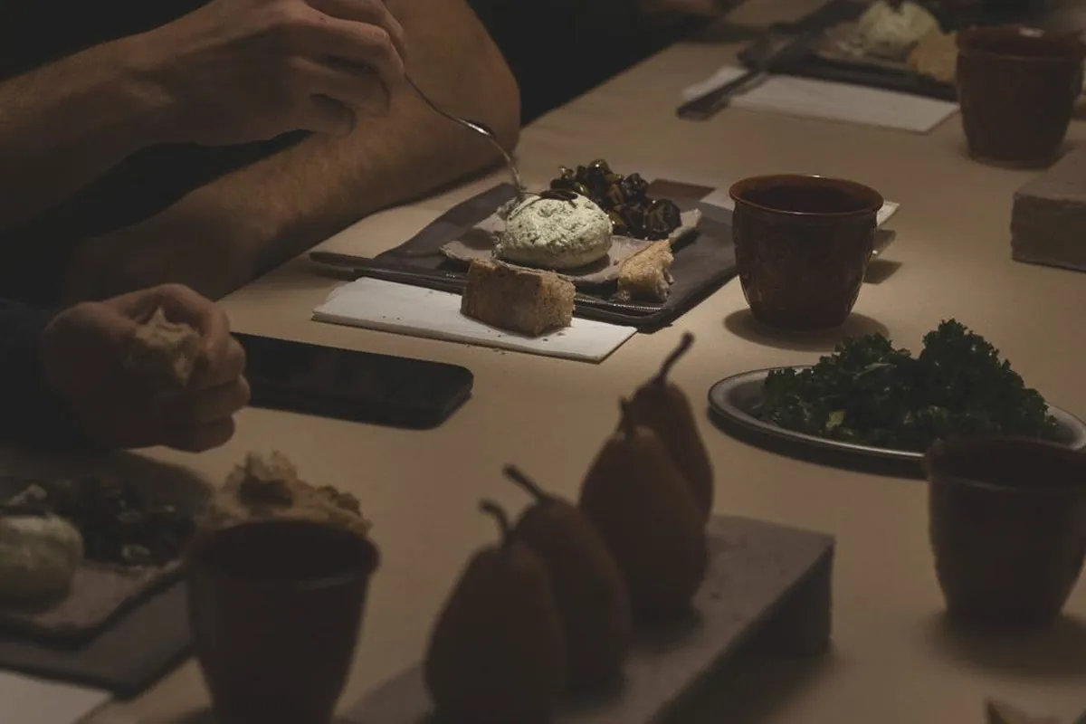 Arkhestia sofrasında tabaklar ve masaya uzanan eller