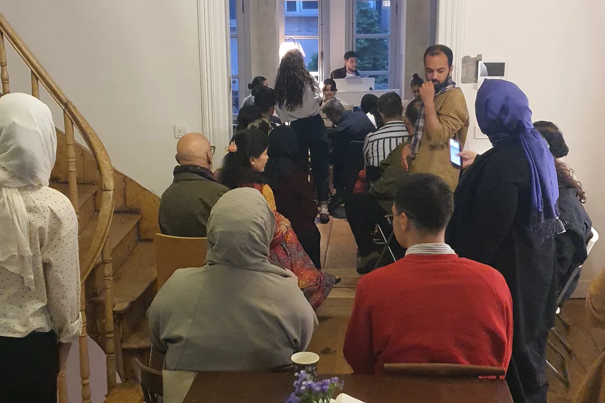 Konseri izleyen kalabalık, merdiven ve çiçekli masa